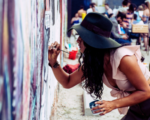 Female artist painting a wall mural