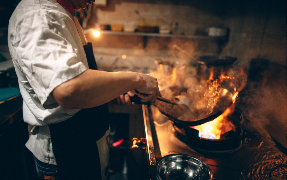 A chef cooking over an open flame